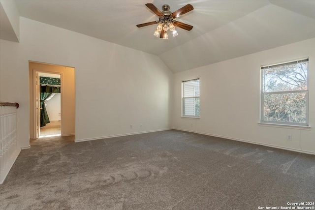 unfurnished room featuring ceiling fan, dark carpet, and lofted ceiling