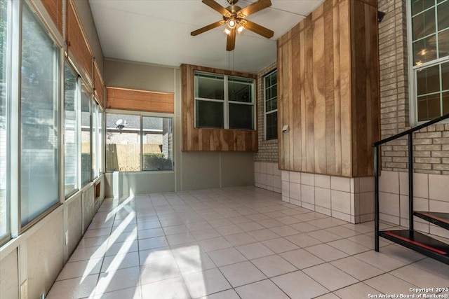 unfurnished sunroom featuring ceiling fan