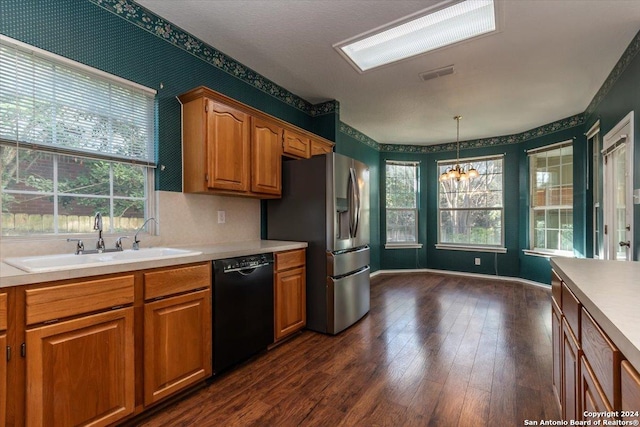 kitchen featuring dark hardwood / wood-style flooring, sink, decorative light fixtures, a chandelier, and black dishwasher