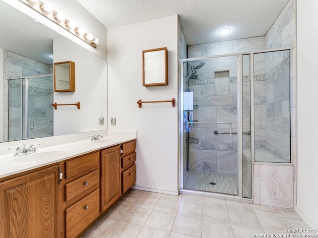 bathroom with walk in shower, tile patterned floors, vanity, and a textured ceiling