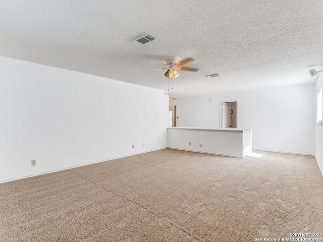 unfurnished living room featuring ceiling fan, light carpet, and a textured ceiling