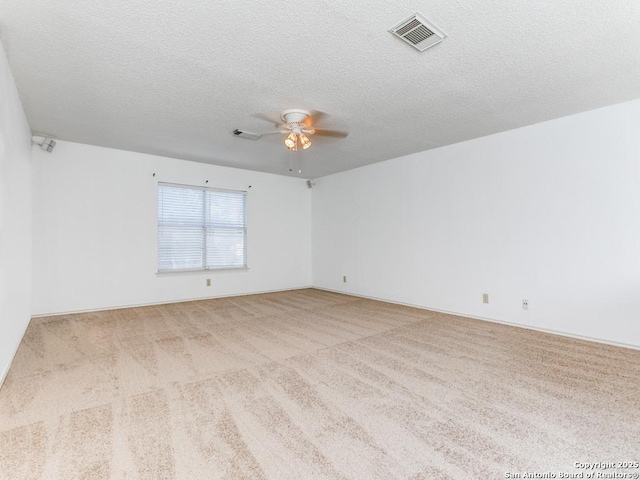 carpeted empty room featuring ceiling fan and a textured ceiling