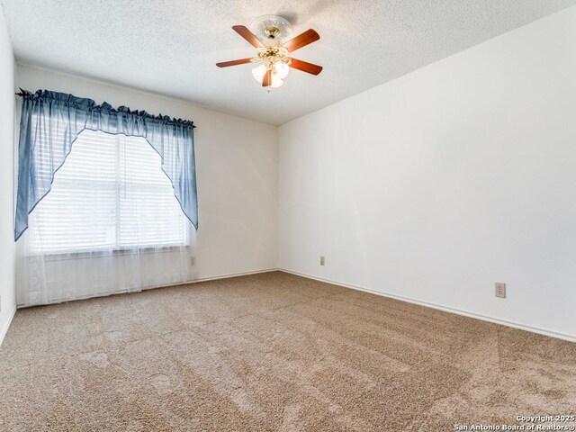 empty room with ceiling fan, carpet floors, and a textured ceiling