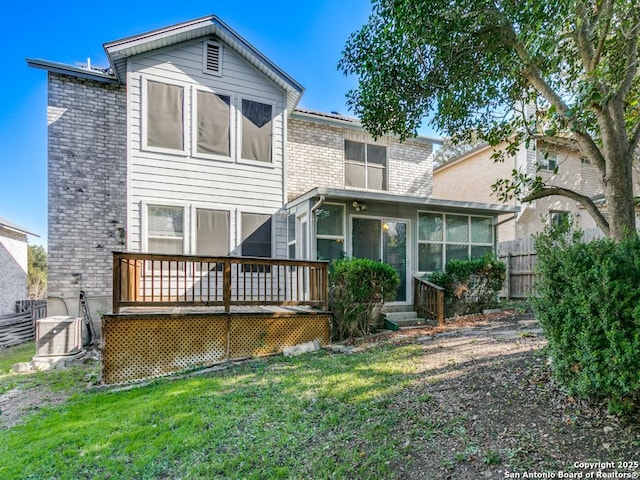 back of property featuring central AC unit, a sunroom, a yard, and a deck