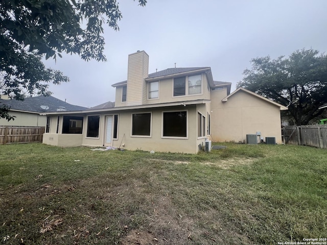 rear view of property with a yard and cooling unit