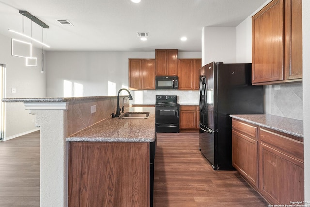 kitchen featuring sink, backsplash, decorative light fixtures, and black appliances