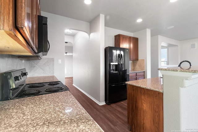 kitchen with electric range, light stone counters, tasteful backsplash, dark hardwood / wood-style flooring, and black fridge with ice dispenser