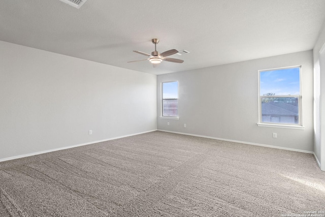 empty room with ceiling fan, carpet floors, and a textured ceiling