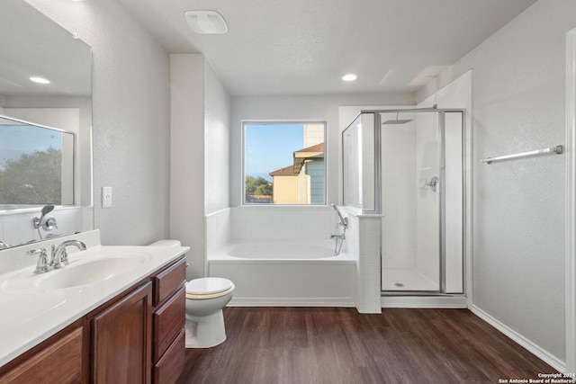 full bathroom featuring hardwood / wood-style floors, vanity, separate shower and tub, toilet, and a textured ceiling