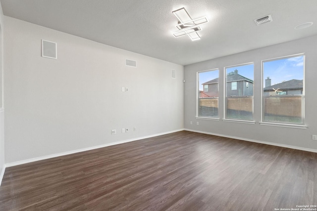 unfurnished room featuring dark hardwood / wood-style floors and a textured ceiling