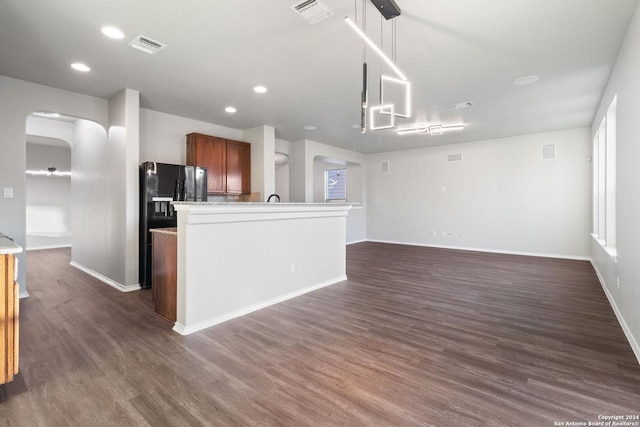 kitchen with pendant lighting, dark hardwood / wood-style flooring, and black refrigerator with ice dispenser