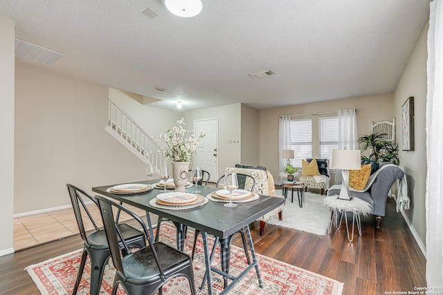 dining area with dark hardwood / wood-style floors and a textured ceiling