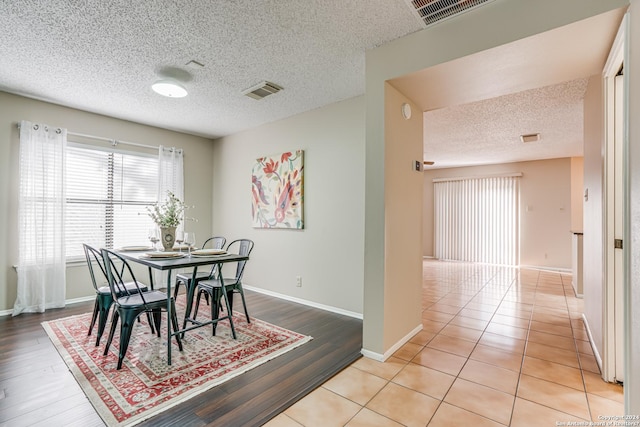 tiled dining room featuring a textured ceiling