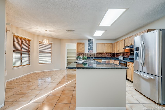 kitchen with backsplash, light tile patterned floors, appliances with stainless steel finishes, a notable chandelier, and a kitchen island