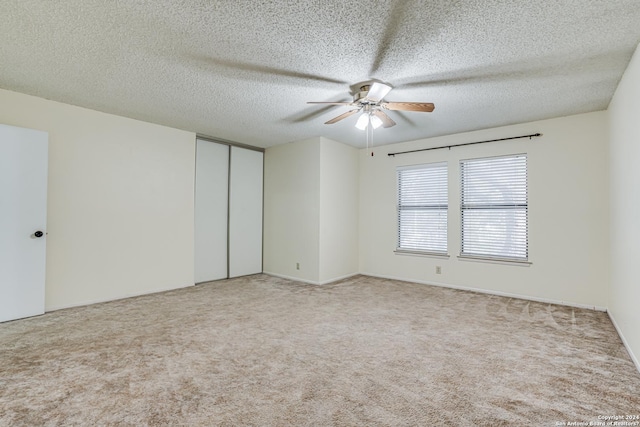 empty room featuring light carpet, a textured ceiling, and ceiling fan