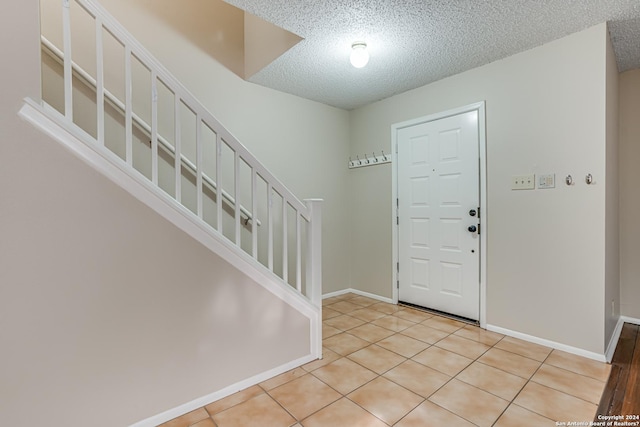 tiled foyer featuring a textured ceiling