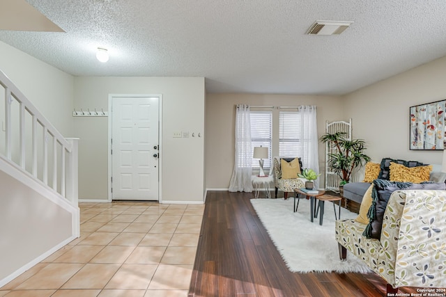 tiled entryway with a textured ceiling