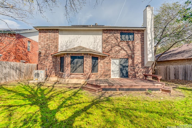 rear view of property featuring a yard, ac unit, and a deck