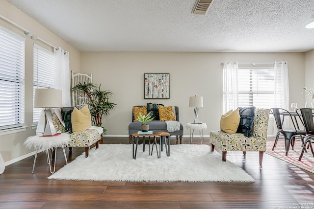 sitting room with a textured ceiling and dark hardwood / wood-style flooring