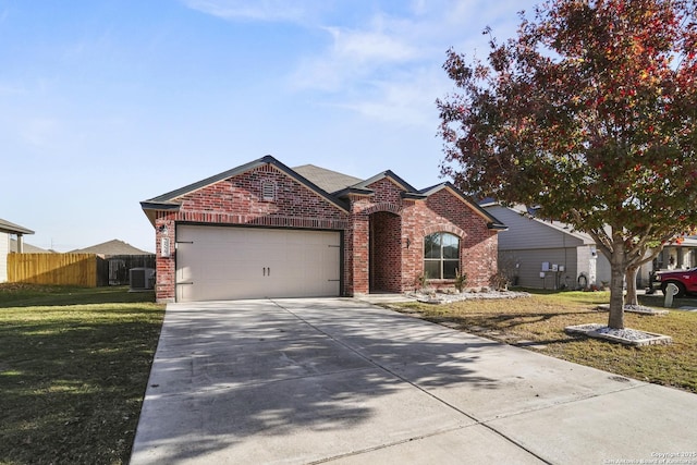 view of front facade with a front yard, central AC, and a garage