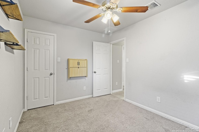 unfurnished bedroom with ceiling fan and light colored carpet