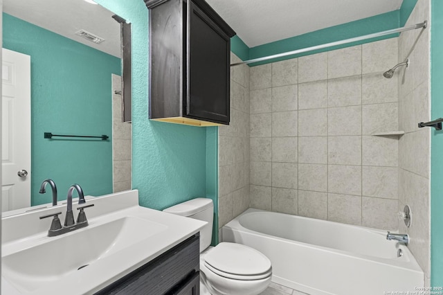 full bathroom featuring tiled shower / bath combo, toilet, a textured ceiling, and vanity