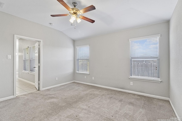 empty room featuring ceiling fan, plenty of natural light, light colored carpet, and lofted ceiling