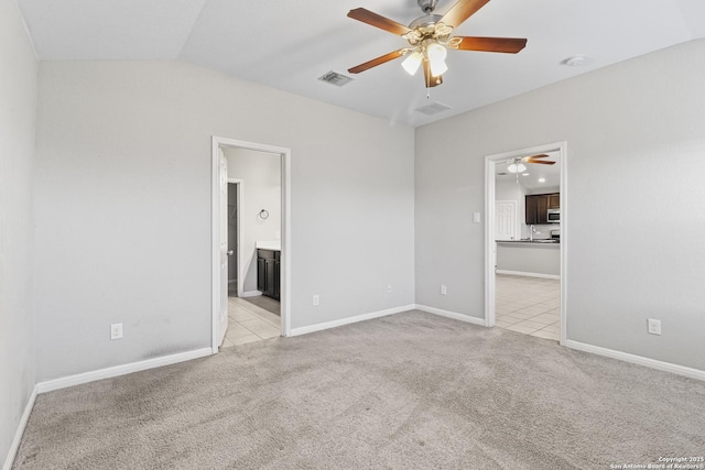 unfurnished bedroom featuring connected bathroom, light colored carpet, ceiling fan, and lofted ceiling