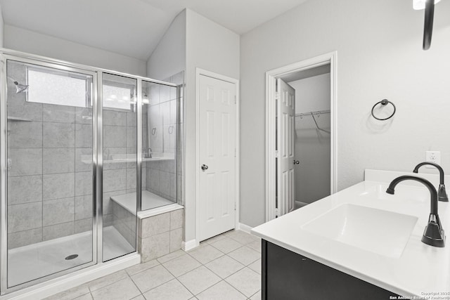 bathroom with tile patterned flooring, vanity, and walk in shower