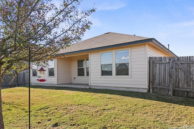 rear view of house featuring a lawn