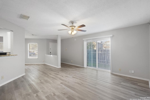 unfurnished living room featuring a textured ceiling, light hardwood / wood-style flooring, plenty of natural light, and ceiling fan