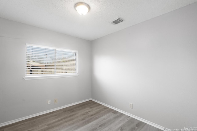 unfurnished room featuring a textured ceiling and hardwood / wood-style flooring