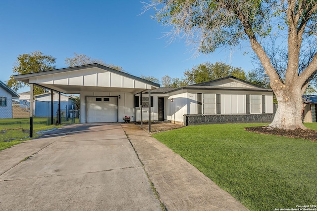 view of front facade with a front lawn, a garage, and a carport