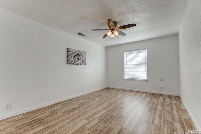 spare room with ceiling fan, a textured ceiling, and light hardwood / wood-style flooring