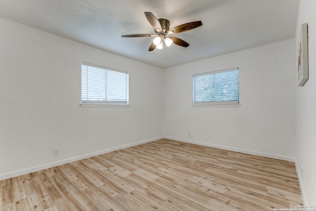 unfurnished room with plenty of natural light, ceiling fan, and light wood-type flooring