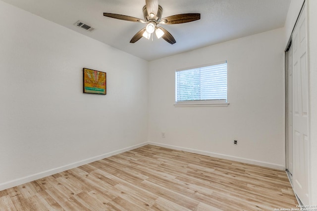 spare room with ceiling fan and light wood-type flooring