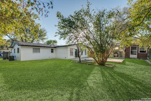 back of house with a yard, cooling unit, and a patio