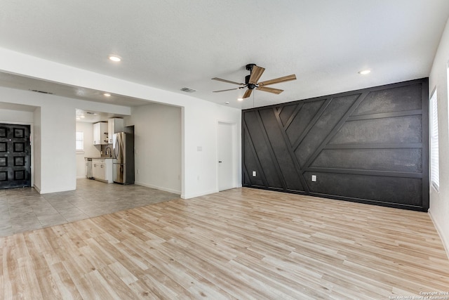 spare room with a textured ceiling, ceiling fan, light hardwood / wood-style floors, and sink