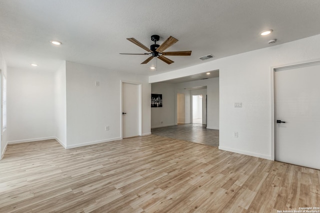 spare room with ceiling fan, light hardwood / wood-style floors, and a textured ceiling