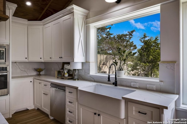 kitchen featuring white cabinetry, sink, stainless steel appliances, and light stone counters