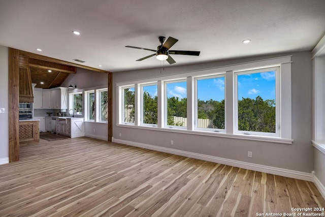 unfurnished living room featuring ceiling fan, light hardwood / wood-style floors, and vaulted ceiling