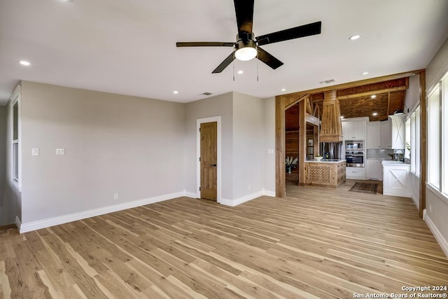 unfurnished living room with ceiling fan and light hardwood / wood-style flooring