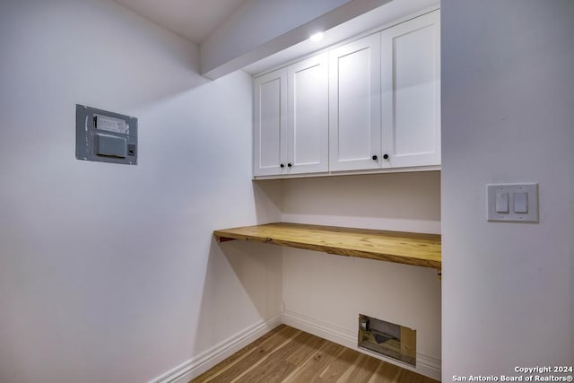 washroom featuring washer hookup, cabinets, and light wood-type flooring