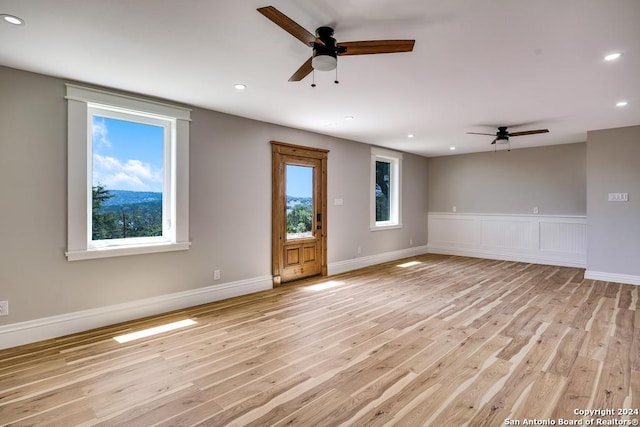 unfurnished room with light wood-type flooring and ceiling fan