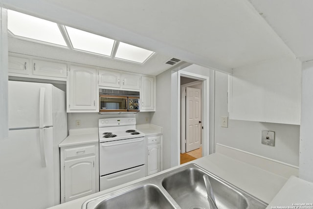 kitchen with white cabinets, white appliances, and sink