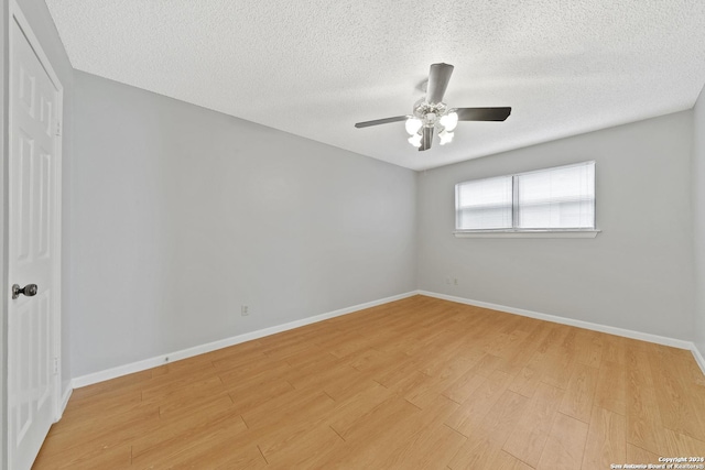 spare room with ceiling fan, light hardwood / wood-style floors, and a textured ceiling