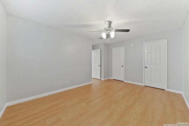 spare room featuring a textured ceiling, light hardwood / wood-style flooring, and ceiling fan