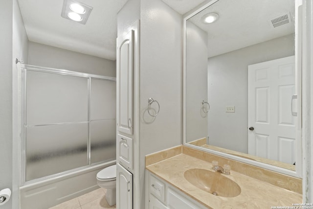 full bathroom featuring tile patterned floors, vanity, toilet, and bath / shower combo with glass door