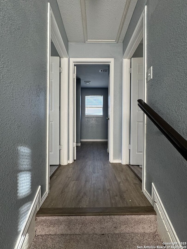 hall featuring dark hardwood / wood-style flooring and a textured ceiling