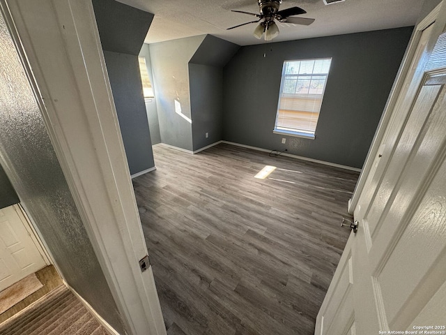 additional living space with a textured ceiling, dark hardwood / wood-style floors, and ceiling fan